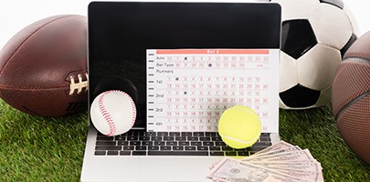 laptop near sports balls and betting list on green grass laptop near sports balls and betting list on green grass